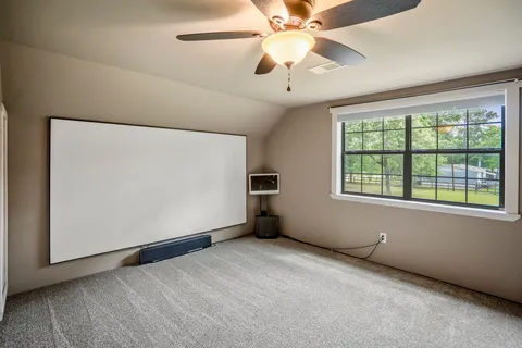 an empty room with windows and fan