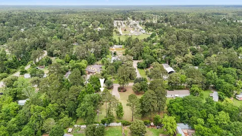 an aerial view of residential houses with outdoor space and trees