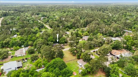 an aerial view of residential houses with outdoor space and trees