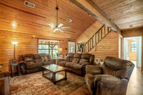 a living room with furniture a ceiling fan and a window