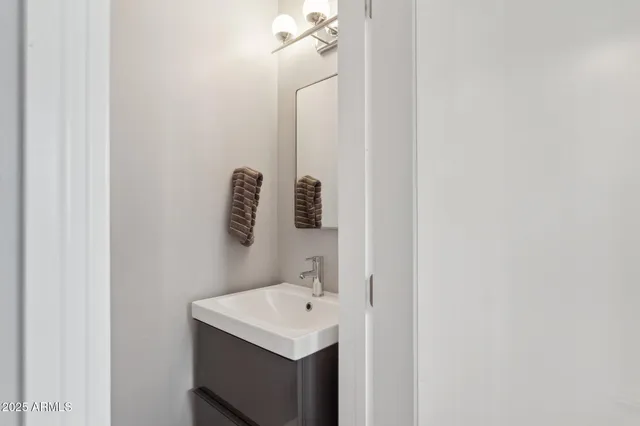 a view of an empty room with wooden floor and windows