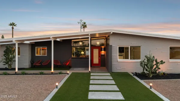 an aerial view of a house with swimming pool and large trees