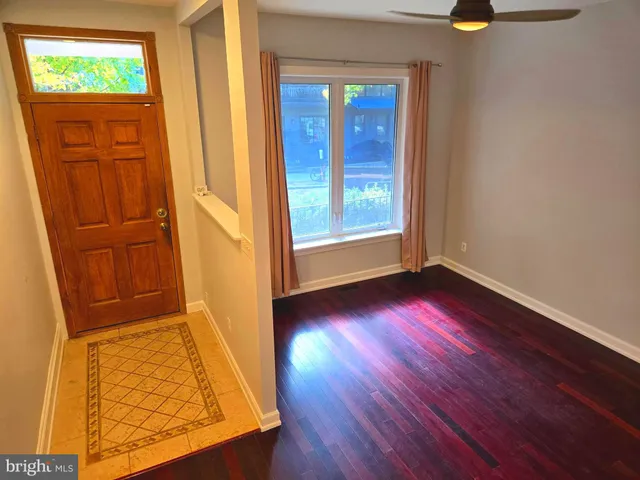 an empty room with wooden floor cabinet and windows