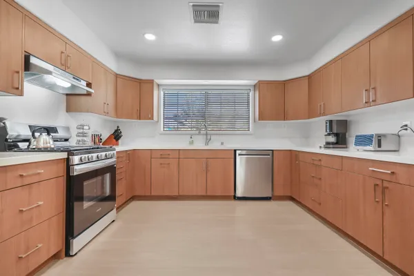 a kitchen with granite countertop a sink stainless steel appliances and cabinets