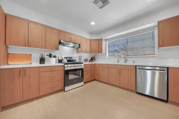 a kitchen with granite countertop white cabinets and white stainless steel appliances