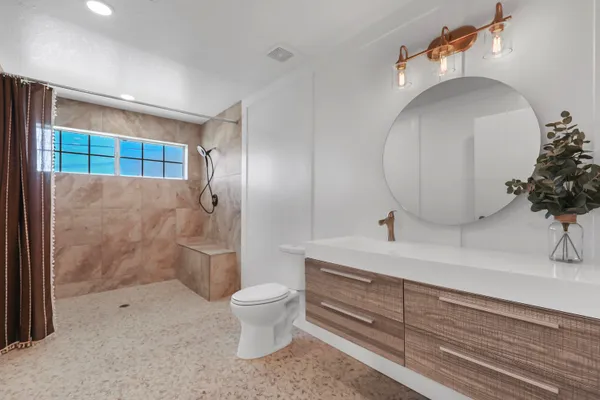 a spacious bedroom with a bed and a flat screen tv