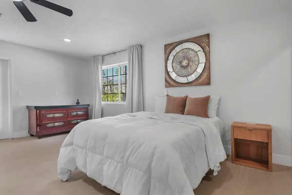 a spacious bedroom with a bed and a chandelier