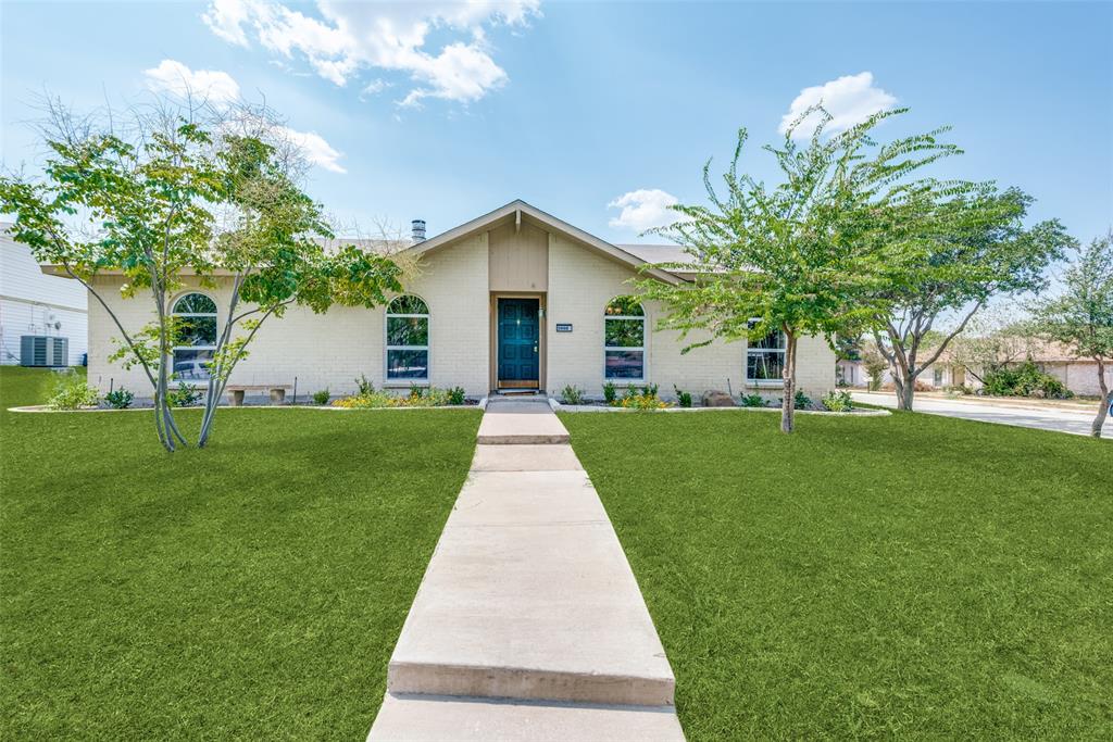 a front view of a house with a yard and trees
