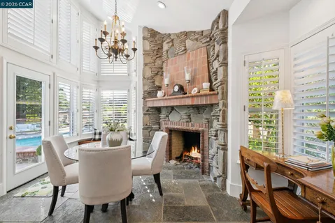 a living room with furniture a fireplace and a potted plant