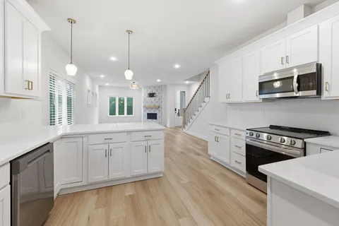 a kitchen with stainless steel appliances granite countertop a stove a sink and a microwave