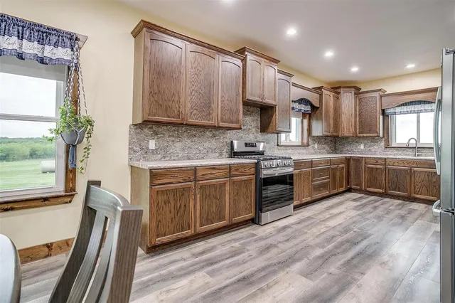 a kitchen with kitchen island granite countertop wooden cabinets and white appliances