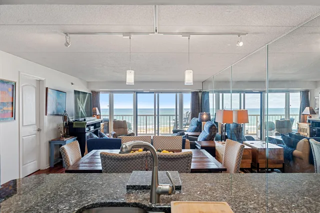 a living room with furniture floor to ceiling window and couch