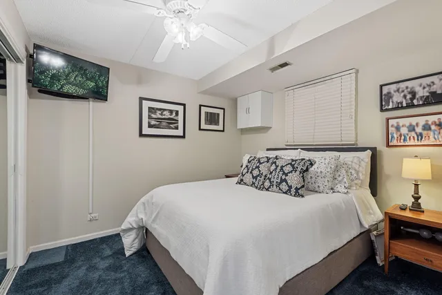 a bedroom with a bed and a lamp on dresser