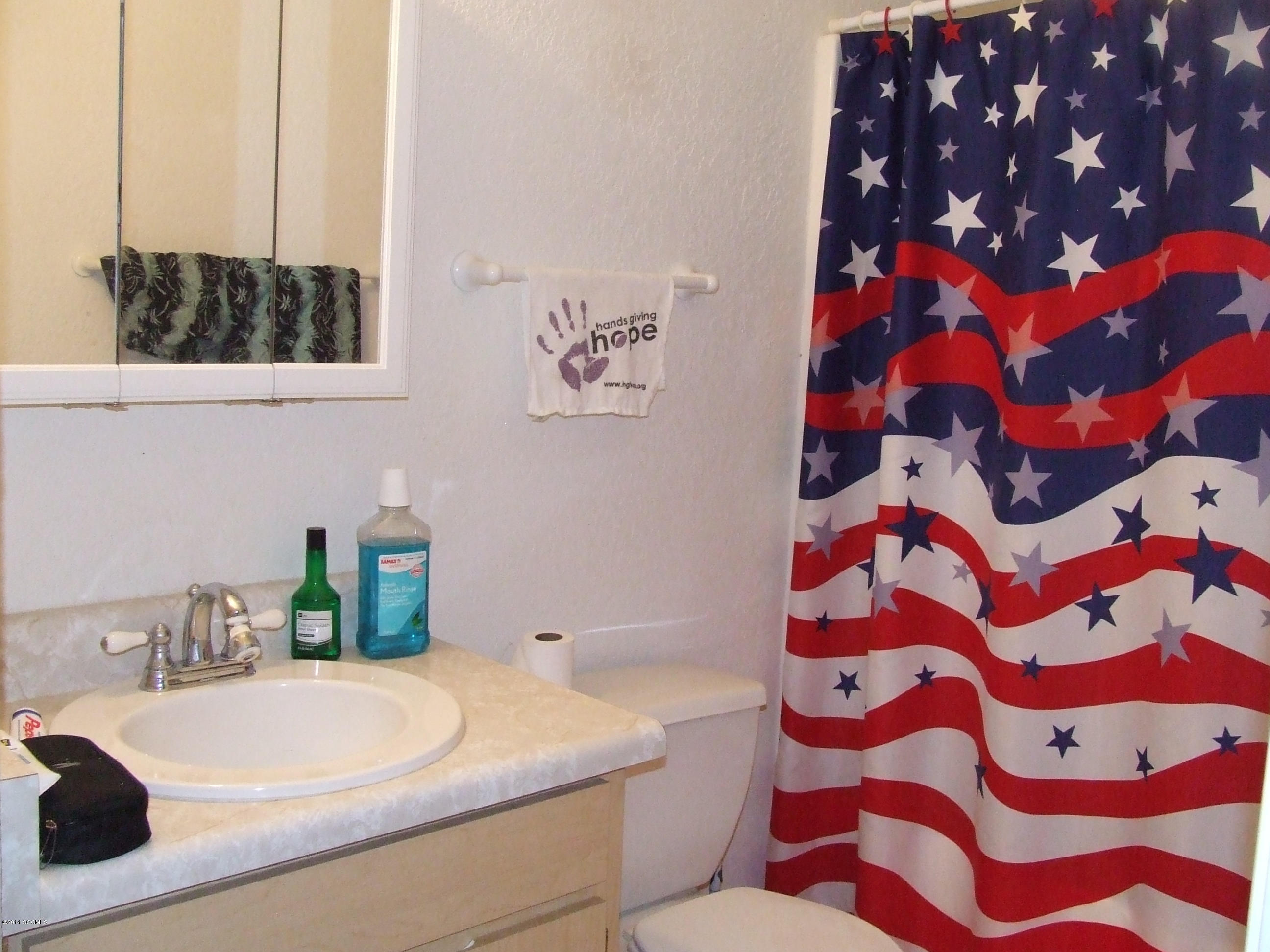 1143 Pedro Court Rio Rico, AZ 85648 - Photo 5 of 14 a bathroom with a sink a toilet and a mirror