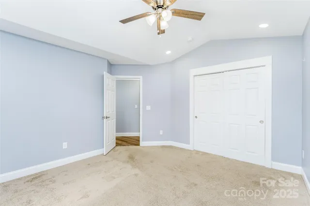an empty room with a ceiling fan and a window