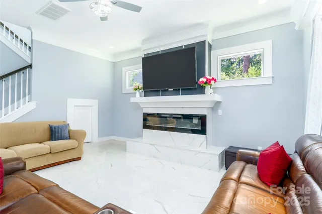 a living room with furniture a flat screen tv and a fireplace