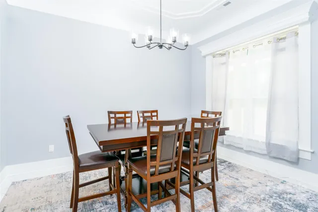 a view of a dining room with furniture and chandelier