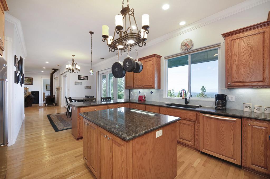5901 Traverse Creek Road Garden Valley, CA 95633 - Photo 47 of 98 a kitchen with stainless steel appliances granite countertop a sink a stove and a wooden floors