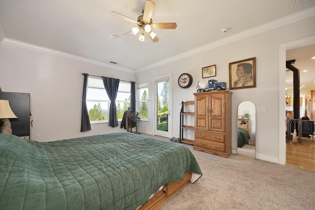 5901 Traverse Creek Road Garden Valley, CA 95633 - Photo 60 of 98 a spacious bedroom with a large bed and a chandelier