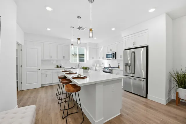 a kitchen with stainless steel appliances kitchen island a refrigerator and a sink