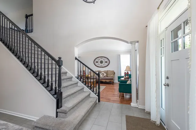 a view of staircase with lots of frames on wall and a window