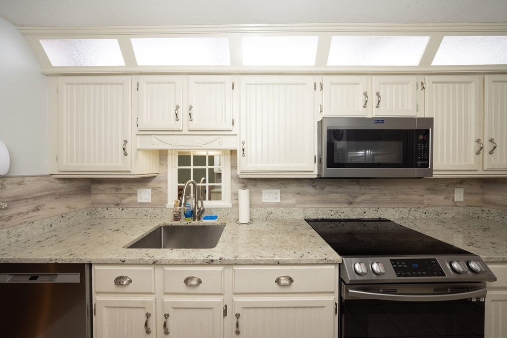1195 Grafton Street, Unit 19 Worcester, MA 01604 - Photo 12 of 22 a kitchen with granite countertop a stove a sink and a microwave