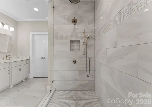 a bathroom with a granite countertop shower two mirror and a sink