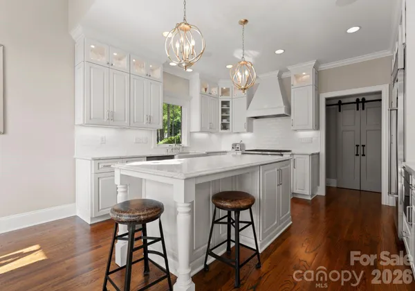 a kitchen with kitchen island granite countertop a sink cabinets and wooden floor