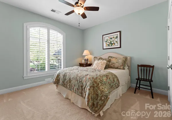 a spacious bedroom with a bed and a chandelier
