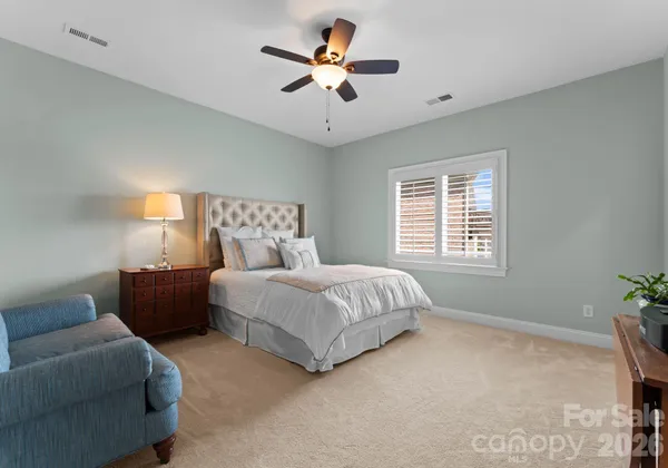 a spacious bedroom with a bed couch and window