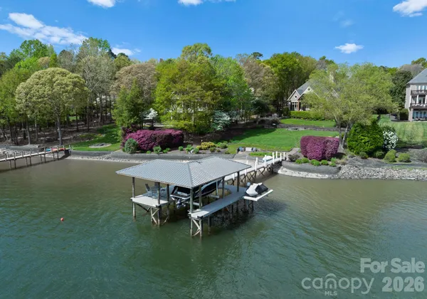 an aerial view of a house with a garden and lake view