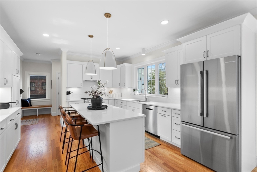 96 Winchester Road Arlington, MA 02474 - Photo 3 of 34 a kitchen with stainless steel appliances a refrigerator a sink dishwasher a stove and white cabinets with wooden floor