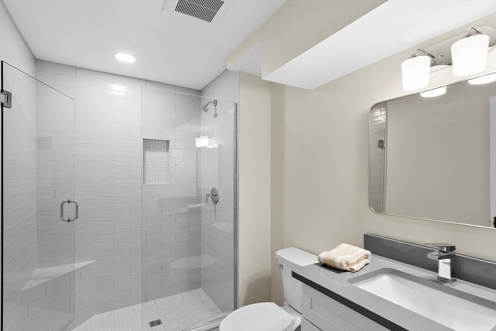 96 Winchester Road Arlington, MA 02474 - Photo 33 of 34 a bathroom with a granite countertop sink a toilet and shower