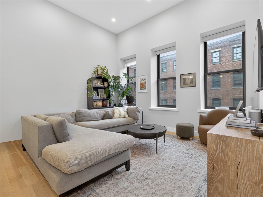 355 Congress Street, Unit 501 Boston, MA 02210 - Photo 1 of 16 a living room with furniture and a window