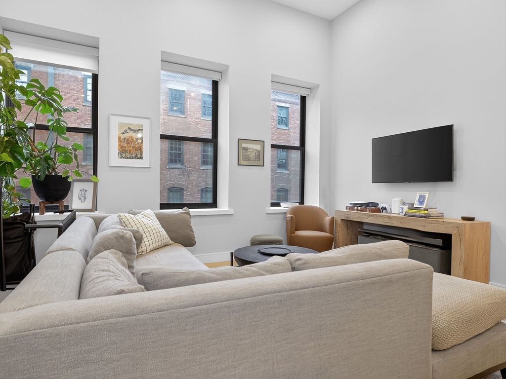 355 Congress Street, Unit 501 Boston, MA 02210 - Photo 2 of 16 a living room with furniture and a flat screen tv
