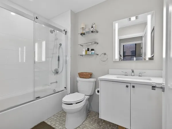 a bathroom with a sink a toilet and shower