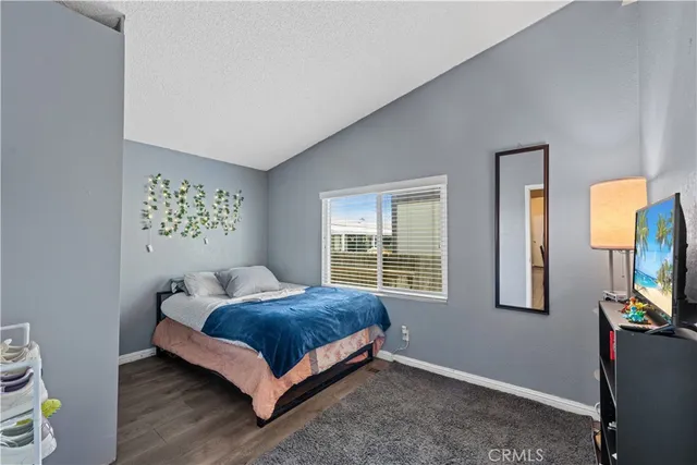 a bedroom with a bed and a flat tv screen on a dresser