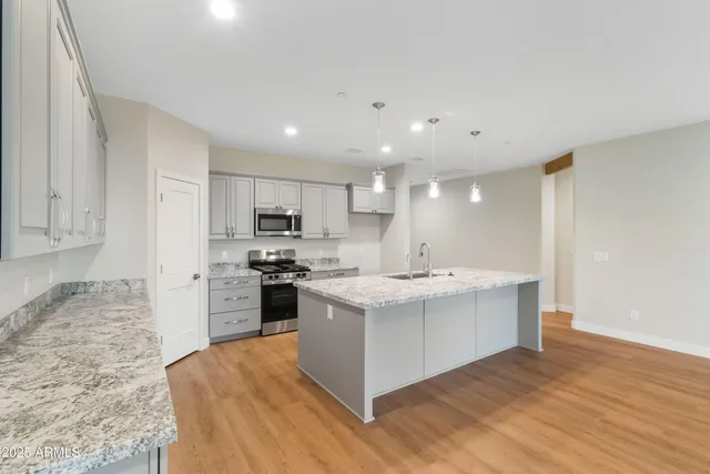 a kitchen with a sink stove top oven and refrigerator