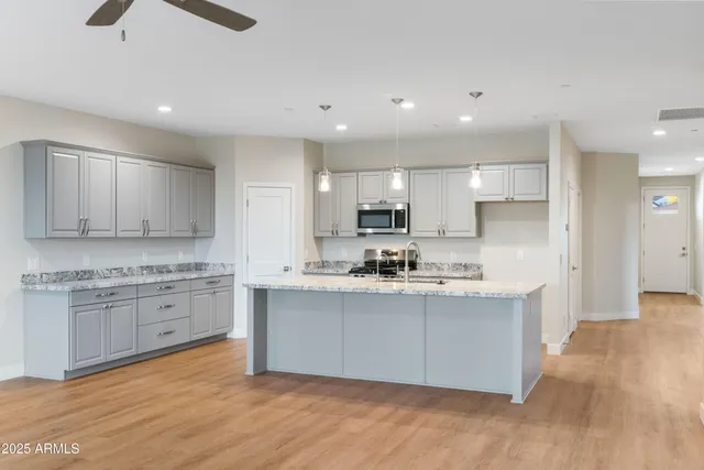 a kitchen with sink a microwave and cabinets