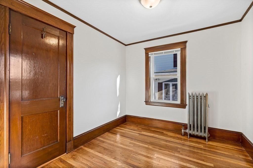 9 Upland Road Winchester, MA 01890 - Photo 28 of 42 a view of an empty room with wooden floor and a window