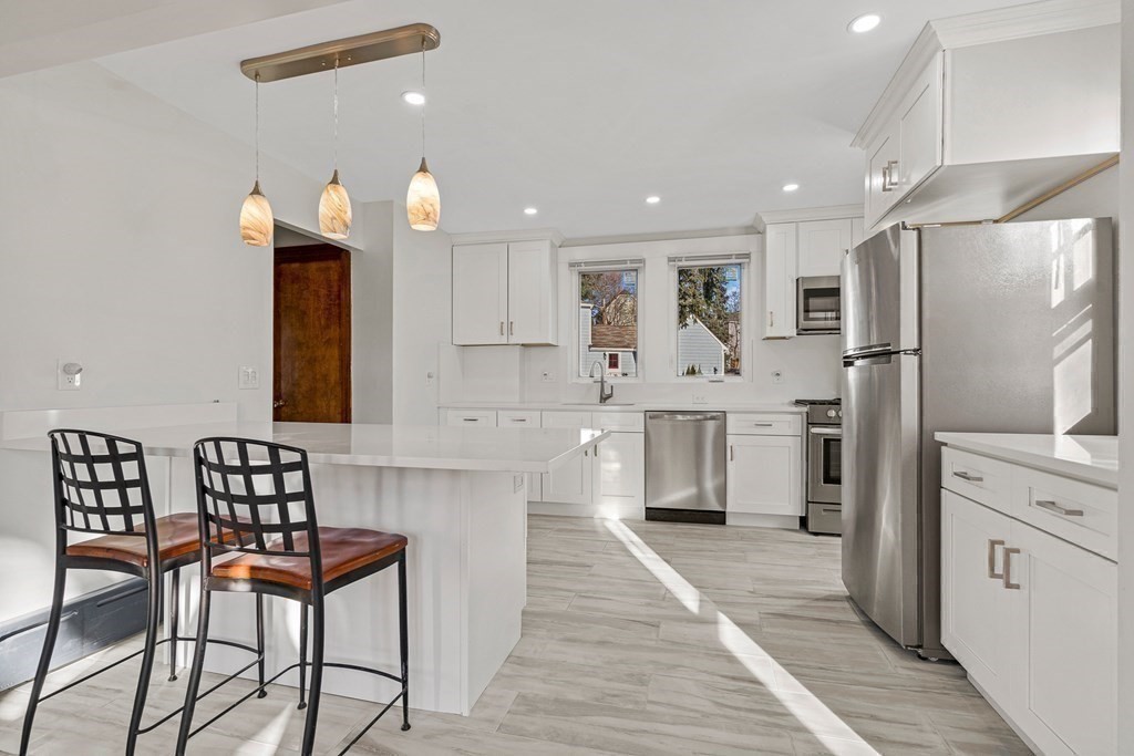 9 Upland Road Winchester, MA 01890 - Photo 7 of 42 a kitchen with stainless steel appliances kitchen island granite countertop a refrigerator and a stove top oven