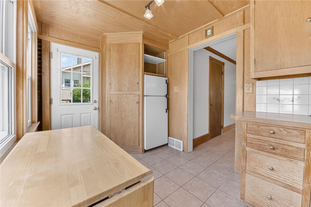 1166 Stones Crossing Road Easton, PA 18045 - Photo 15 of 35 A compact kitchen with warm wood paneling and a practical tile floor offers a cozy cooking space.