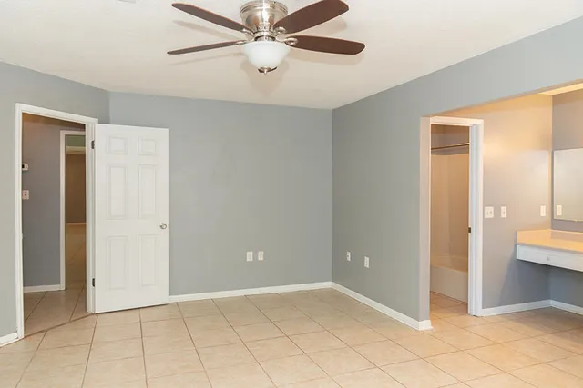 an empty room with closet and a chandelier fan