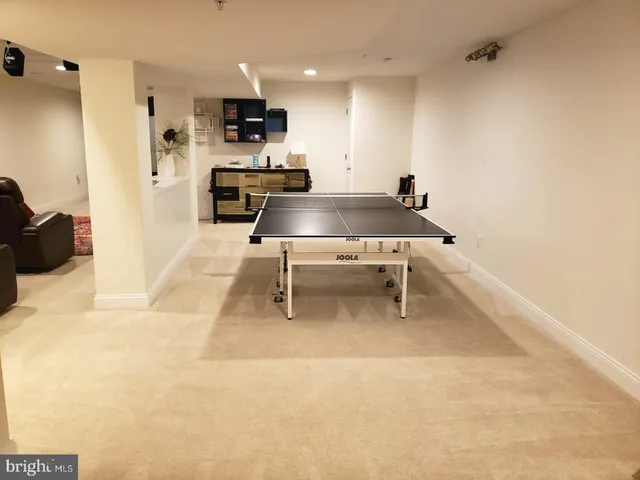 a living room with stainless steel appliances kitchen island granite countertop a sink and a refrigerator