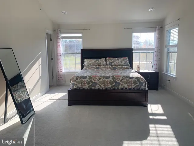 a room with a bed mirror and window