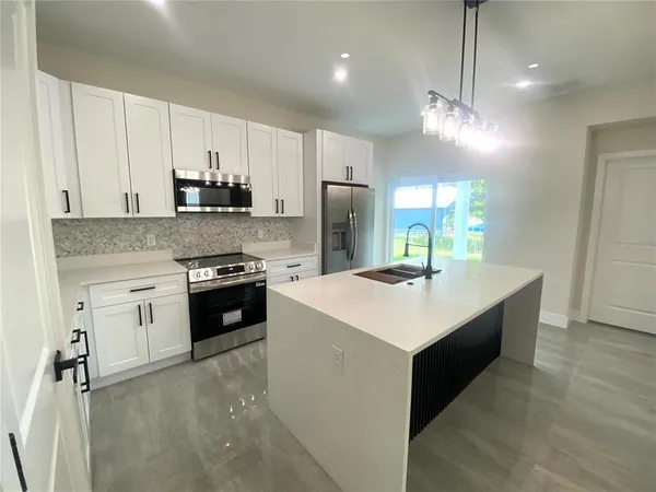 a kitchen with stainless steel appliances a sink stove and refrigerator