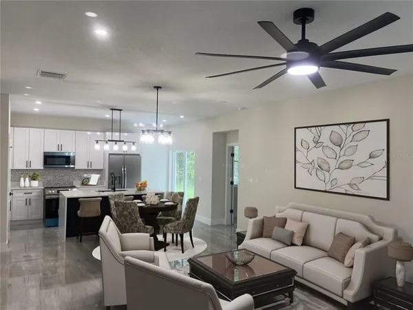 a living room with furniture kitchen view and a chandelier