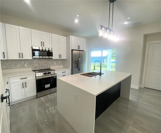 a kitchen with kitchen island a sink appliances and cabinets