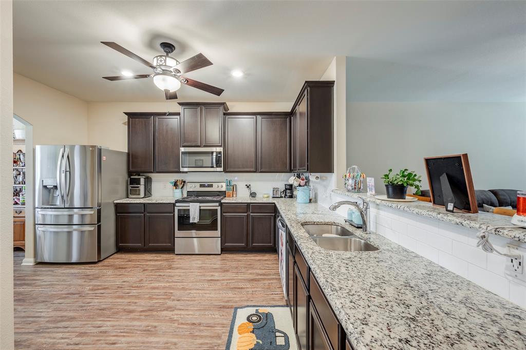 1832 Tyne Way Crowley, TX 76036 - Photo 8 of 25 a kitchen with stainless steel appliances granite countertop a sink stove and refrigerator