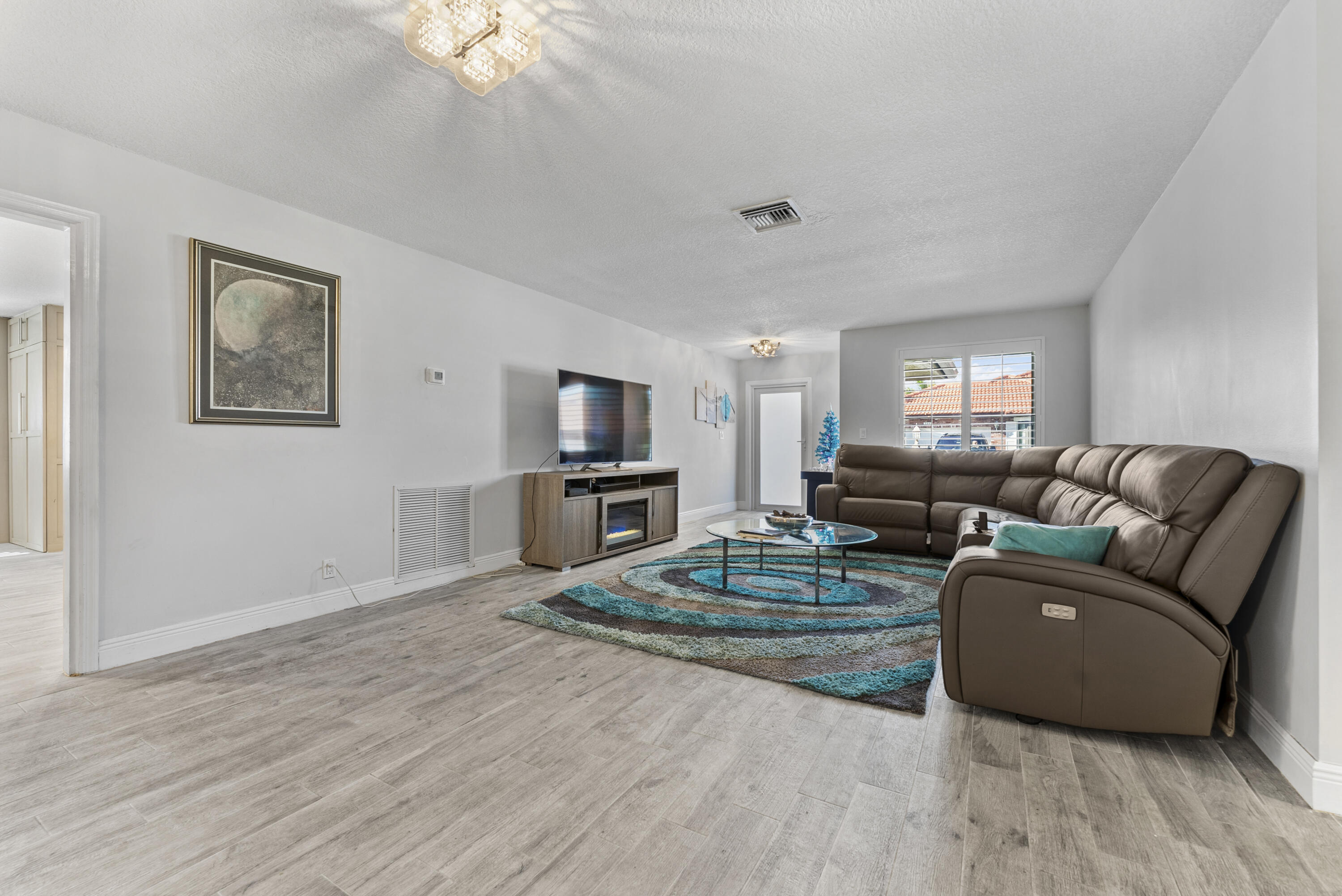 334 Northwest 42nd Street Boca Raton, FL 33431 - Photo 13 of 48 a living room with furniture a flat screen tv and kitchen view